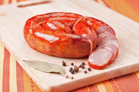 Close-up sausage and pepper on a wooden cutting board. の写真素材