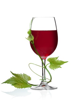 Glass of red wine and grape leaves on a white background and with soft shadow.の写真素材
