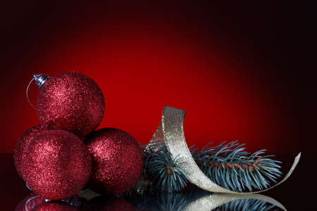 christmas balls and ribbon on a red backgroundの写真素材