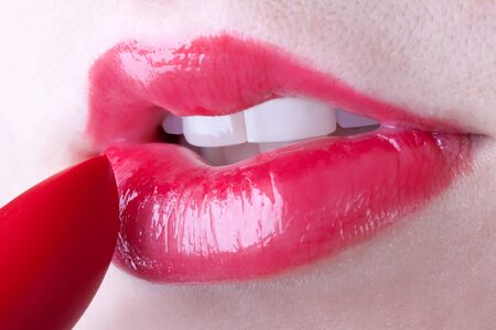 girl applying red lipstickの写真素材