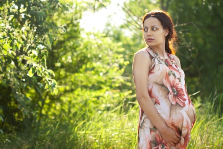 Young pregnant woman relaxing at a parkの写真素材