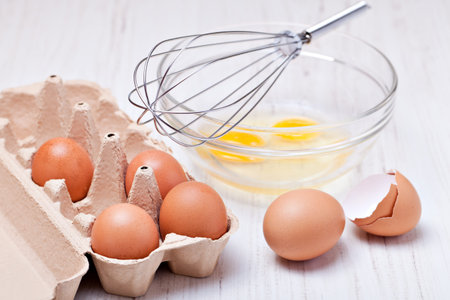 Wire whisk and brown eggs