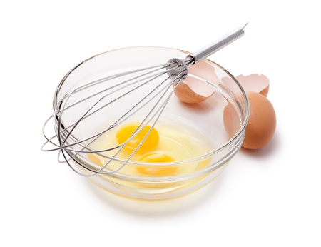 Wire whisk and brown eggs, isolated on white.の写真素材