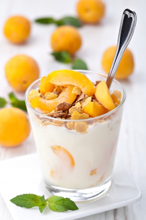 yogurt with muesli and apricot in small glassの写真素材