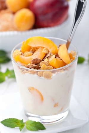 yogurt with muesli and apricot in small glassの写真素材