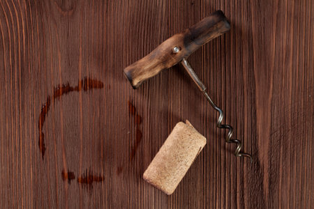 Corkscrew and Cork over wooden background