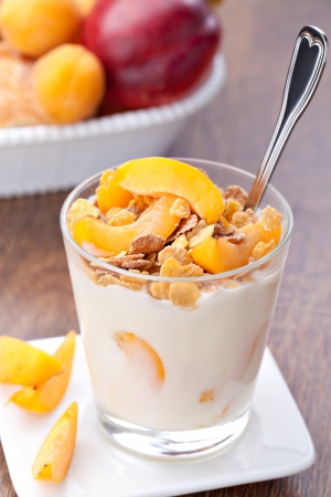yogurt with muesli and apricot in small glassの写真素材