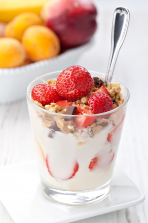 yoghurt with granola and strawberries in glassの写真素材