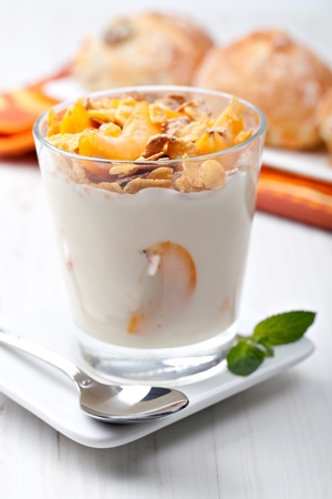 yogurt with muesli and apricot in small glassの写真素材