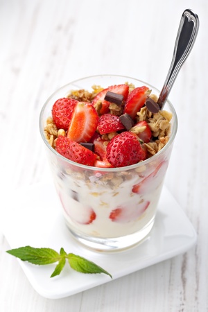 yoghurt with granola and strawberries in glassの写真素材