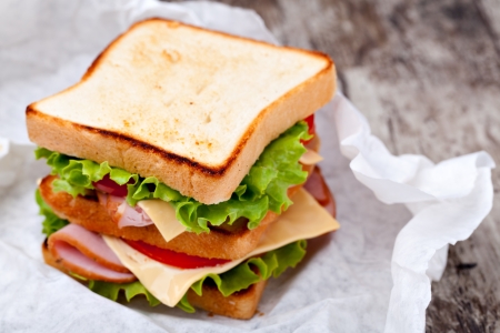 Sandwich with bacon and vegetables on wooden tableの写真素材