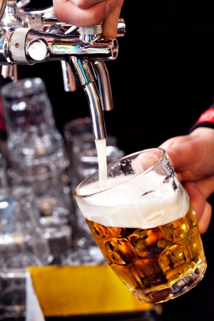 pouring beer into the glassの写真素材