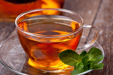 Cup of tea and mint on a wooden backgroundの写真素材