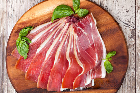 sliced prosciutto on a wooden tableの写真素材