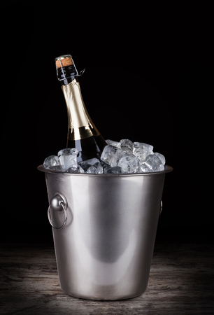 Champagne bottle in a bucket with ice on the dark backgroundの写真素材