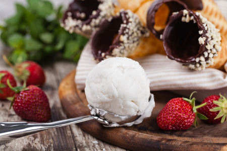 ice cream and strawberries on a wooden tableの写真素材