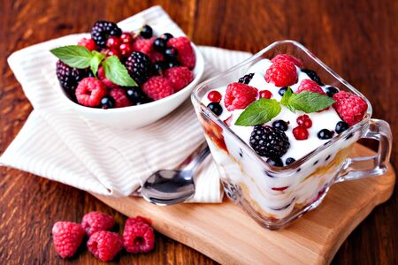 yogurt with muesli and berries on a wooden tableの写真素材