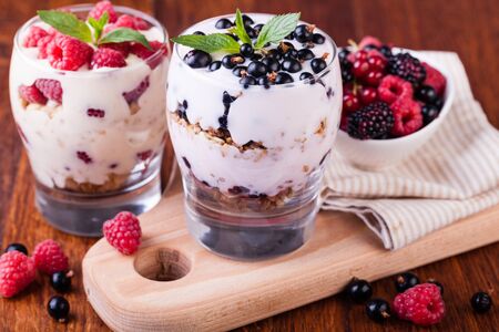 yogurt with muesli and berries on a wooden tableの写真素材