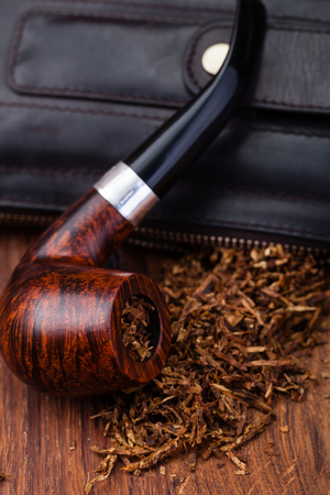 Smoking pipe and tobacco on a wooden tableの写真素材