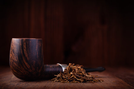 Smoking pipe and tobacco on a wooden table