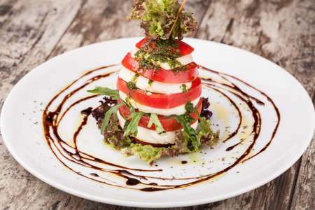 Plate of Healthy Caprese Salad with Mozzarella Cheese, Tomatoes and Basilの写真素材