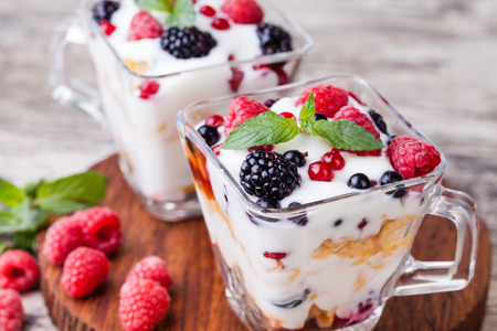 yogurt with muesli and berries on a wooden tableの写真素材