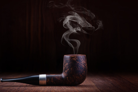 Smoking pipe on a wooden tableの写真素材
