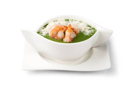 spinach cream soup with shrimp in a white bowlsの写真素材