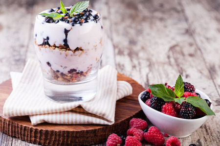 yogurt with muesli and berries on a wooden tableの写真素材