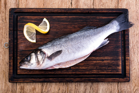 Raw Seabass isolated on a wooden tableの写真素材