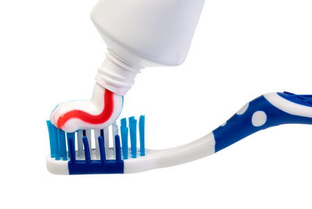 Toothbrush and toothpaste on white background