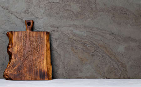 Rustic wooden cutting board on rusty stone backgroundの写真素材