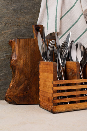 Rustic wooden cutting board and cutlery on rusty stone background