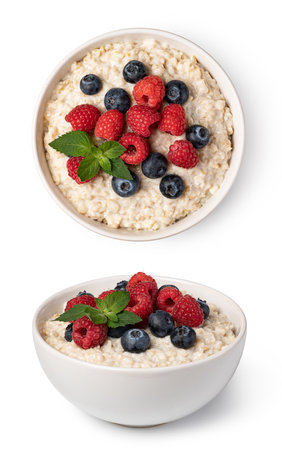 prepared oatmeal with berries isolated on white backgroundの写真素材