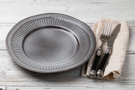 Table setting. plate, knife and fork on a wooden tableの写真素材