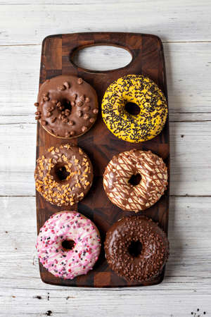 Top view of assorted donuts on a wooden backgroundの写真素材