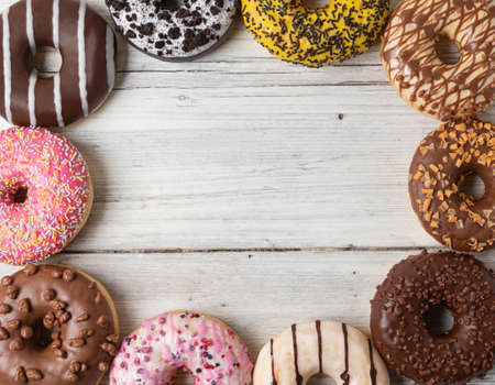 Top view of assorted donuts on a wooden backgroundの写真素材