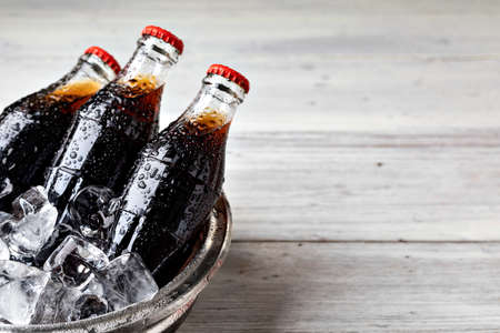 Soda Bottle on Bed of Ice on a wooden tableの写真素材