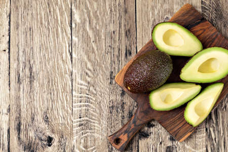 Avocado isolated on a wooden tableの写真素材