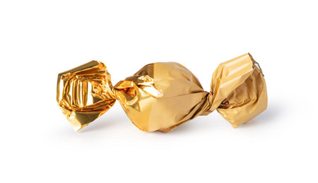 candy in golden wrapper isolated on whiteの写真素材