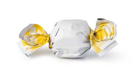 candy in golden wrapper isolated on whiteの写真素材