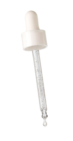 Drop of serum falls from glass pipette on white backgroundの写真素材