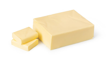 Creamy butter block and cut slices isolated on white, representing dairy products, cooking, and baking ingredientsの写真素材