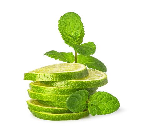 Sliced lime and spearmint on a white background creating a refreshing imageの写真素材