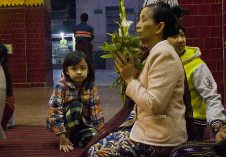 Old Woman Praying at the Buddha with his grandchildのeditorial素材