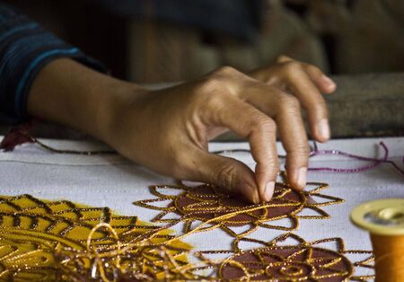 Hand detail of a Burmese woman at work sewing beads のeditorial素材