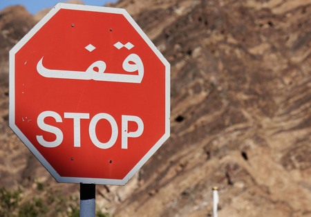 Omani Stop road.sign.The Stop road-sign in Muscat is in dual language, arabic and english. Behind, the Muscat mountainsの写真素材