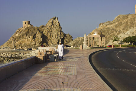 Muscat, Oman, October 19, 2013: A man is walking on Muscat promenade. Facing the Sea, the Muscat sidewalk is a well balanced mix between History and Modernityのeditorial素材