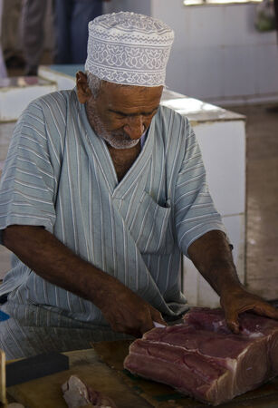 Barka, Oman, October 20, 2013: Daily Fish market in Barka, Oman, were fresh seafood is sold everyday. A man is cutting fresh fish.のeditorial素材