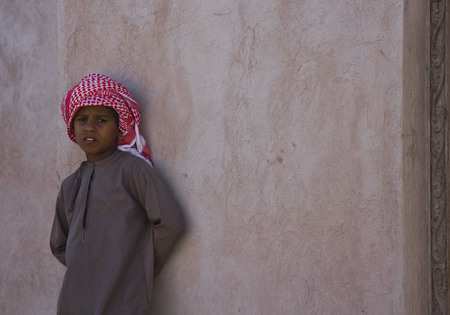 Moqul, Oman, October 22, 2013  A young omani boy standing on a wall  He is wearing the typical hat Mussar  turban のeditorial素材